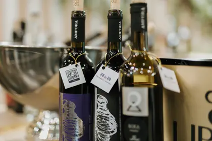 Wine bottles with 28 by 28 branded tags at a campaign event